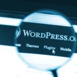 Primer plano del sitio web de Wordpress bajo una lupa. WordPress es una herramienta de blogs gratuita y de código abierto.