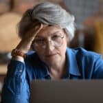 Mujer observa la pantalla de su portátil analizando planes de hosting WordPress.