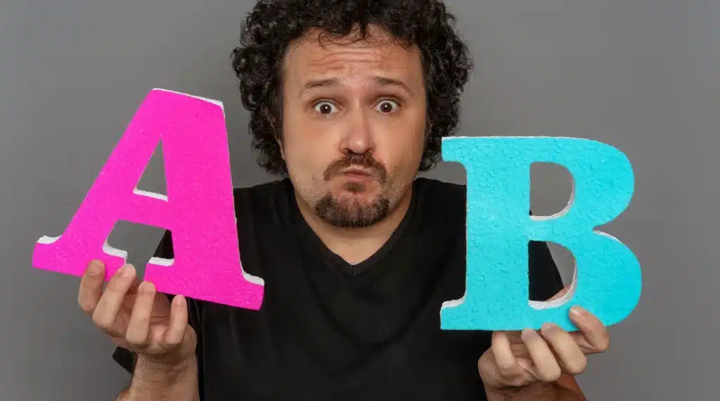 Persona sosteniendo las letras A y B grandes, representando la elección entre opciones en una estrategia de email marketing.