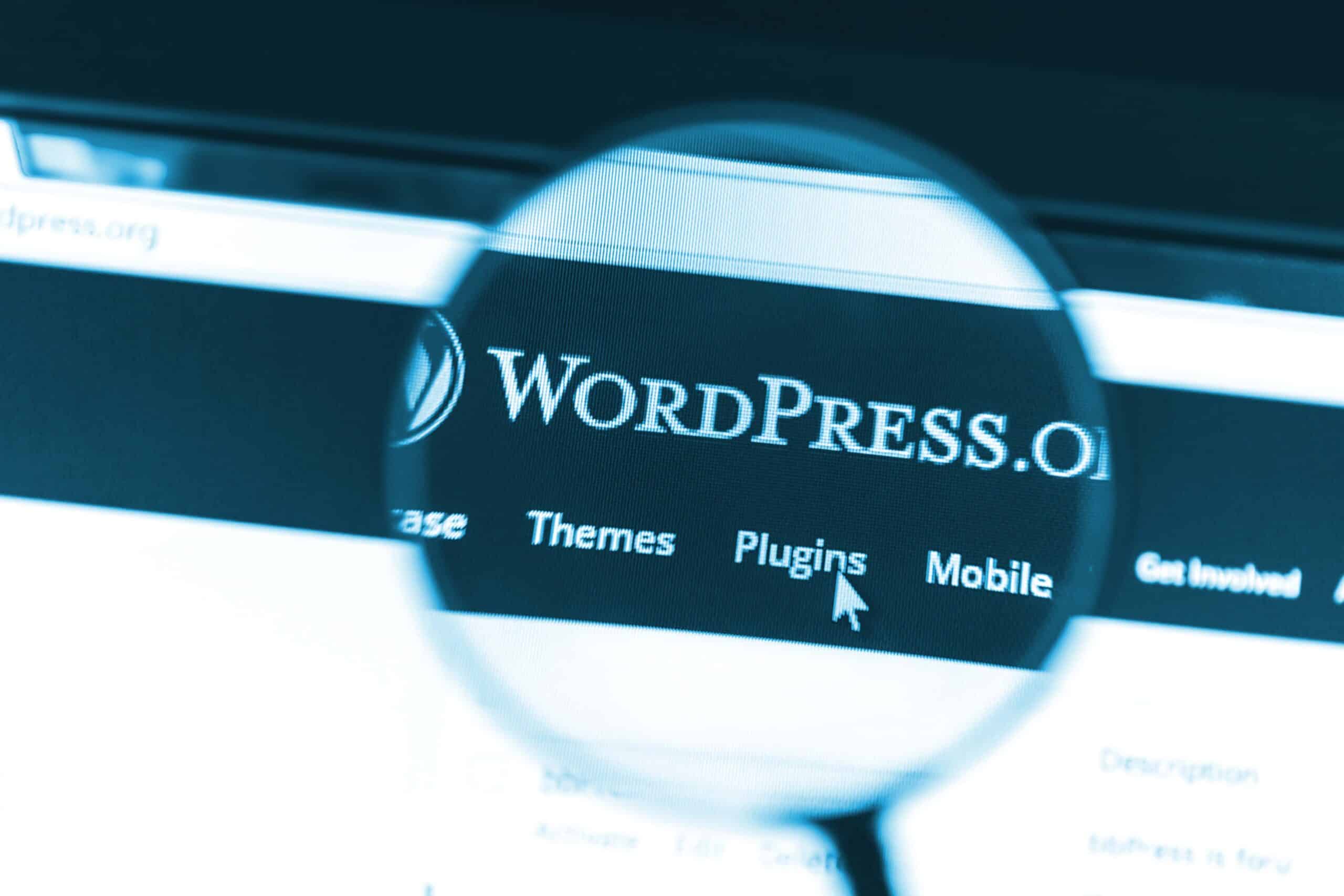 Primer plano del sitio web de WordPress bajo una lupa. WordPress es una herramienta de blogs gratuita y de código abierto.